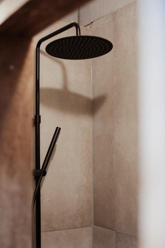a shower with a shower head on a wall at La Maison du Marcel in Sainte-Cécile