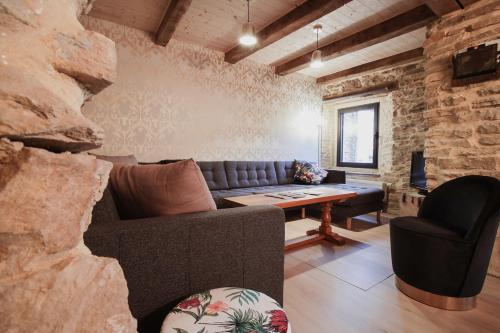 ein Wohnzimmer mit einem Sofa und einem Stuhl in der Unterkunft La Maison du Marcel in Sainte-Cécile