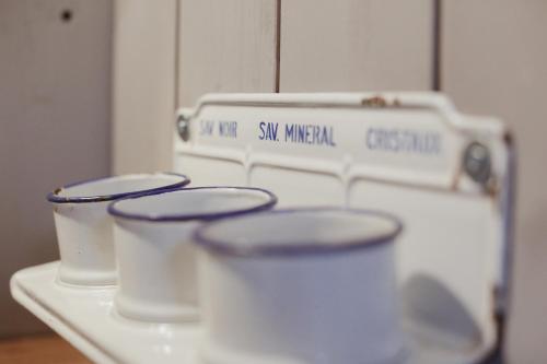 four cups sitting on top of a white table at La Maison du Marcel in Sainte-Cécile