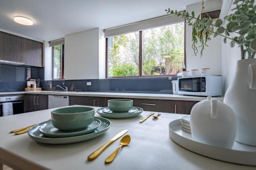eine Küche mit zwei Tassen und Tellern auf dem Tisch in der Unterkunft Moonee Ponds’ hidden gem – 1BR w/ Free Parking in Melbourne