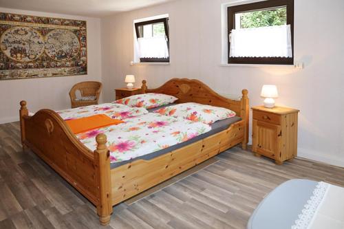 リーブニッツ・ダムガルテンにあるAm Wiesengrund - mit 2 Schlafzimmernのベッドルーム1室(木製ベッド1台、ナイトスタンド2台付)