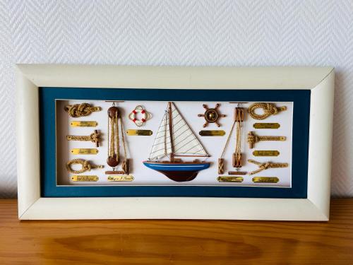 a framed picture of a sailboat and other items at Studio lumineux face mer à Cayeux sur mer in Cayeux-sur-Mer