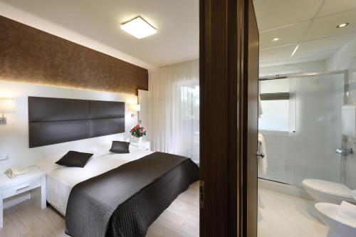 Hotel Eros tesisinde bir odada yatak veya yataklar