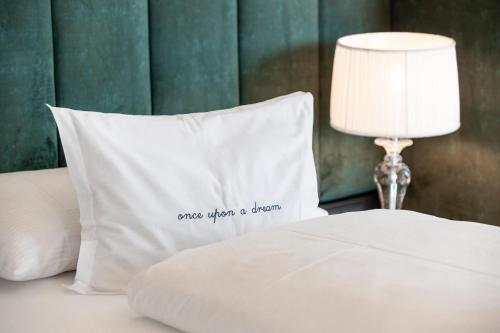 a white pillow on a bed with a lamp at Prunner Luxury Suites - Adults Only in Schenna