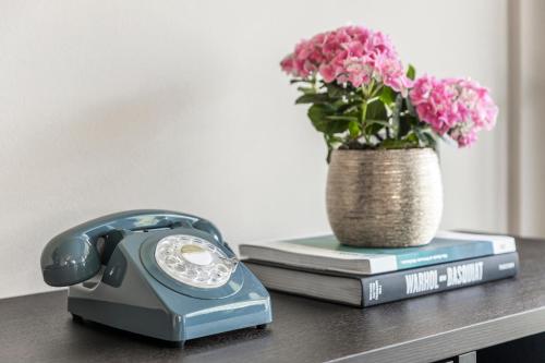 a telephone and a vase of flowers on a table at Prunner Luxury Suites - Adults Only in Schenna