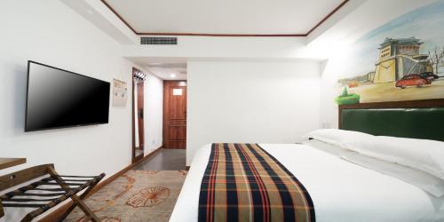 - une chambre avec un lit et une télévision à écran plat dans l'établissement Nostalgia Hotel Beijing - Tian'anmen Square, à Pékin