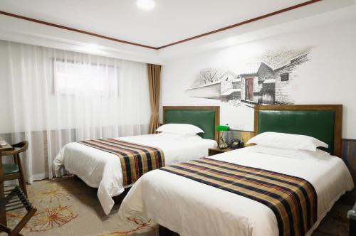 a hotel room with two beds and a painting on the wall at Nost algia Hotel Beijing Tiananmen Square & Qianmen Subway St ation 时光漫步酒店 北京天安门广场前门地铁站店 Free laundry service in Beijing