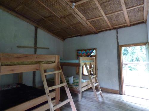 um quarto com 2 beliches e uma janela em Nshongi Camp em Rubuguli