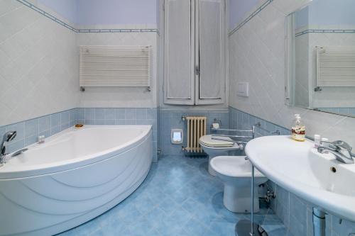 ein Badezimmer mit einer Badewanne, 2 Waschbecken und einem WC in der Unterkunft Florence Quiet Apartment with Private Garden in Florenz