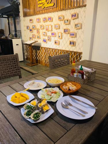 a wooden table with plates of food on it at Paradise Resort Doc Let - All Inclusive in Doc Let