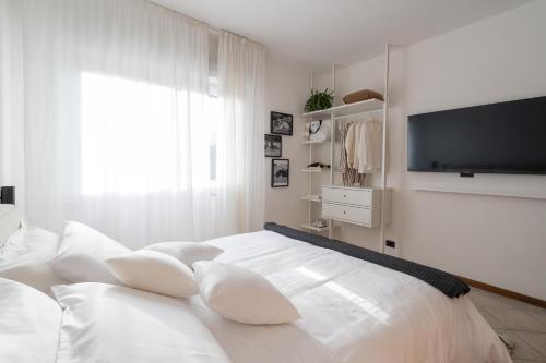 1 dormitorio blanco con 1 cama blanca grande con almohadas en Hotel Adriatica con Piscina, en Riccione