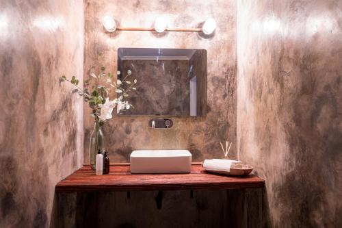 W łazience znajduje się umywalka i lustro. w obiekcie Sunbirds Oasis Lodge w mieście Hoedspruit