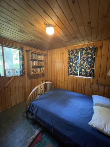 um quarto com uma cama num quarto de madeira em GREENS LIMIT 6 cottage 