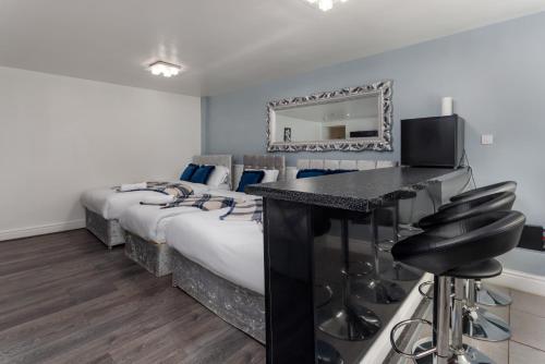 1 dormitorio con 1 cama y escritorio con TV en Snuggle Cove Apartments By Snazzy Short stay en Liverpool