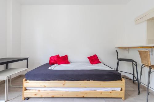 um quarto com uma cama com almofadas vermelhas em Cénoslocs Bondy - Joli meublé pour 4 personnes avec Jardin & Wifi em Bondy