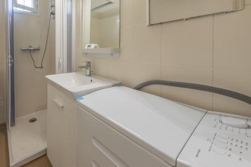 a white bathroom with a sink and a mirror at Cénoslocs Bondy - Paris à vos pieds pour 4 personnes avec Jardin & Wifi in Bondy