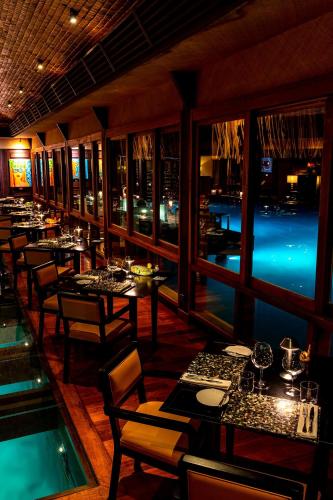 a restaurant with tables and chairs and a view of the water at The St. Regis Bora Bora Resort in Bora Bora