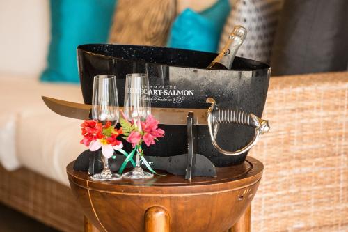 a table with two champagne glasses and flowers on it at The St. Regis Bora Bora Resort in Bora Bora