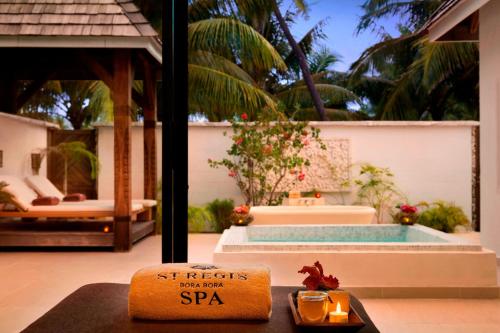 a spa sign sitting on a table next to a pool at The St. Regis Bora Bora Resort in Bora Bora