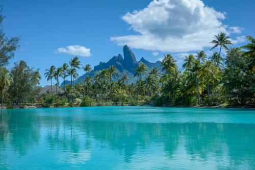 a view of a tropical island with palm trees and mountains at The St. Regis Bora Bora Resort in Bora Bora