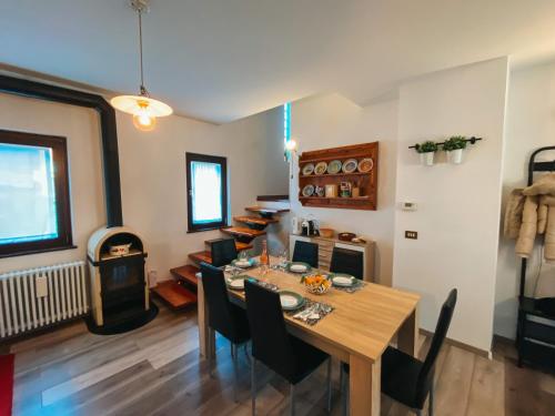 a dining room with a wooden table and chairs at Appartamento panoramico in Sùtrio