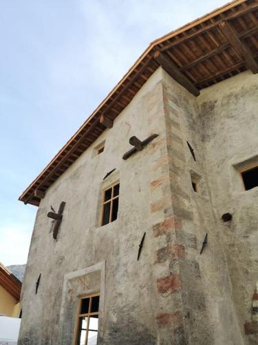 a building with a clock on the side of it at Historisches Townhouse in Prad in Prato allo Stelvio