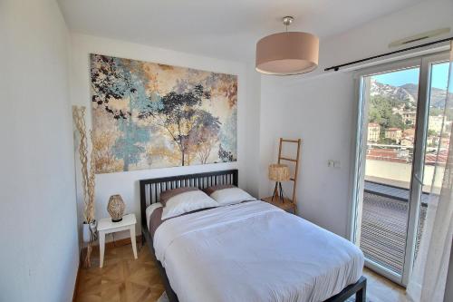 a bedroom with a bed and a painting on the wall at Luxury Monaco Sea View Penthouse Le Lord in Beausoleil