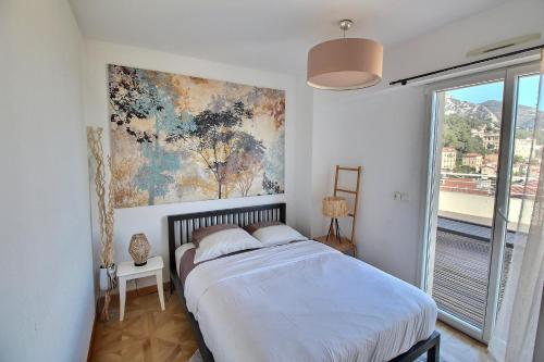 ボーソレイユにあるLuxury Monaco Sea View Penthouse Le Lordのベッドルーム1室(ベッド1台付)が備わります。壁には絵画が飾られています。