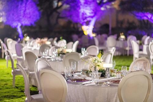 a table set up for a wedding with white tables and chairs at Al Messila, A Luxury Collection Resort & Spa, Doha in Doha