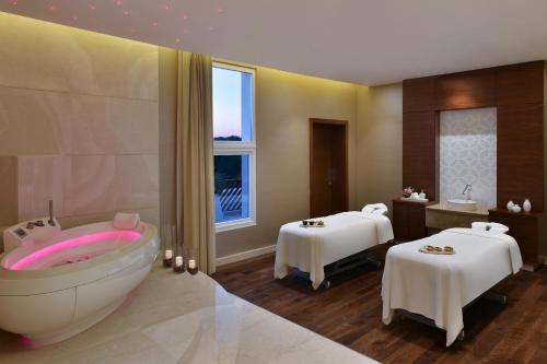 a bathroom with a bath tub and two tables at Al Messila, A Luxury Collection Resort & Spa, Doha in Doha
