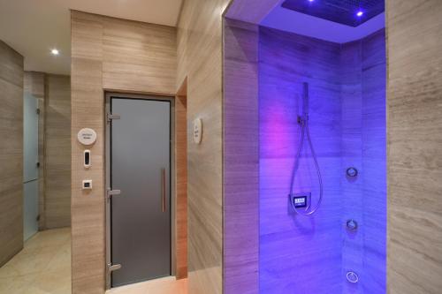 a bathroom with a shower with purple tiles at Al Messila, A Luxury Collection Resort & Spa, Doha in Doha