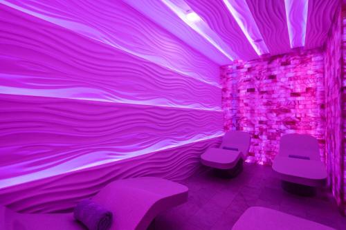 a purple room with purple chairs and a wall at Al Messila, A Luxury Collection Resort & Spa, Doha in Doha