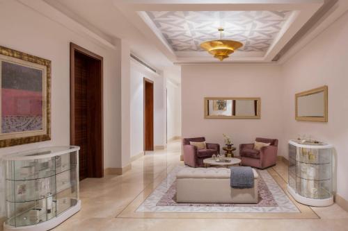 a living room with a couch and chairs and a ceiling at Al Messila, A Luxury Collection Resort & Spa, Doha in Doha