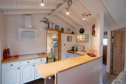a kitchen with white cabinets and a wooden counter top at The Tao House in Sheringham