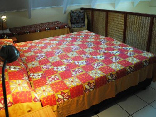 a bed with a colorful quilt on it in a room at Whitesands Beach Villas in Rarotonga