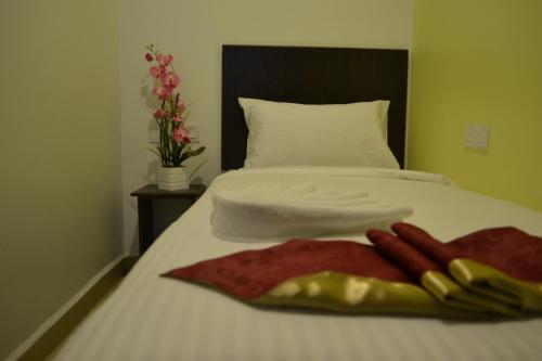 a white bed with a bunch of hot dogs on it at DR Hotel Penang in Bayan Lepas