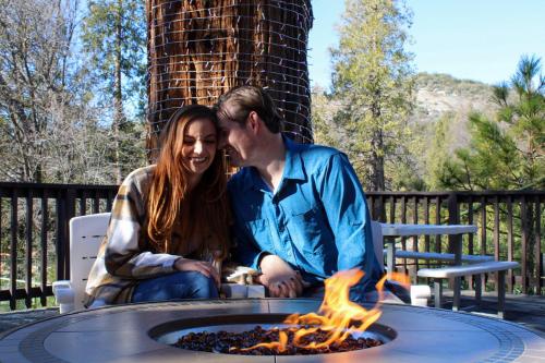 a man and woman sitting around a fire pit at The Pines Resort & Conference Center in Bass Lake