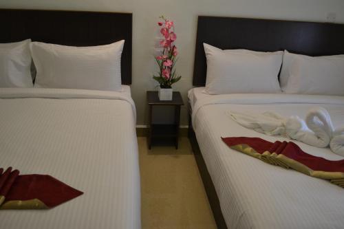 two beds sitting next to each other in a room at DR Hotel Penang in Bayan Lepas