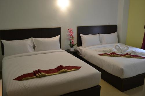 two beds in a hotel room with towels on them at DR Hotel Penang in Bayan Lepas