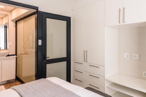 a bedroom with white cabinets and a black door at The Regency Apartments in Pretoria
