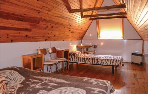 Habitación con 2 camas, mesa y sillas en Awesome Home In Le Cayrol With Kitchenette, en Le Cayrol