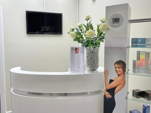 a woman is standing next to a vase of flowers at Oatlands Park Hotel in Weybridge