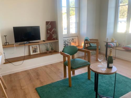 un soggiorno con TV, sedie e tavolo di Appartement du Port - Audierne ad Audierne