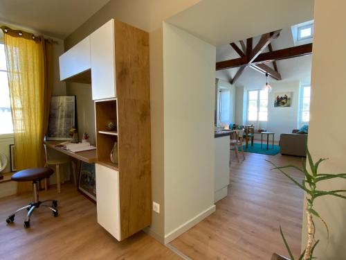 uma cozinha e sala de estar com uma secretária e uma mesa em Appartement du Port - Audierne em Audierne