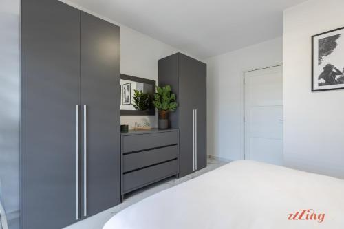 a bedroom with a bed and a black cabinet at St Paul's 3BR Apartment - Spectacular Sea Views in St. Paul's Bay