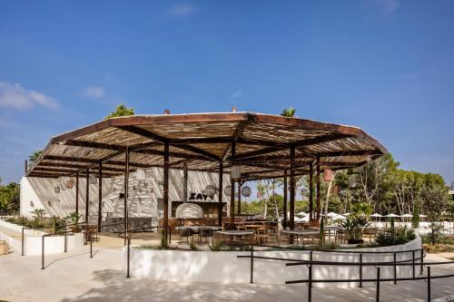 a large wooden pavilion with tables and benches at Kimpton Aysla Mallorca by IHG in Santa Ponsa