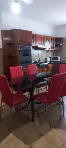 cocina con sillas rojas y mesa de comedor en Casa Privada Monte Grande y cochera en Monte Grande