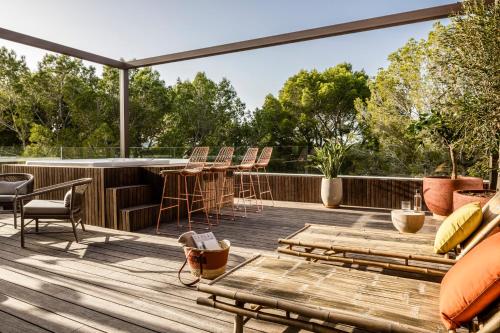 a deck with chairs and tables and a bar at Kimpton Aysla Mallorca by IHG in Santa Ponsa