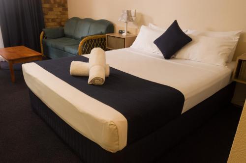 una habitación de hotel con una cama con un animal de peluche. en Lancaster Court Motel en Brisbane