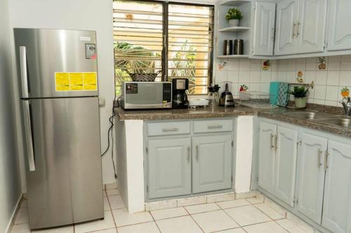 a kitchen with white cabinets and a stainless steel refrigerator at casa acogedora de 3 habitaciones in Santa Bárbara de Samaná